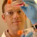 Dr Koch holds up 2 plastic bottles containing stem cells